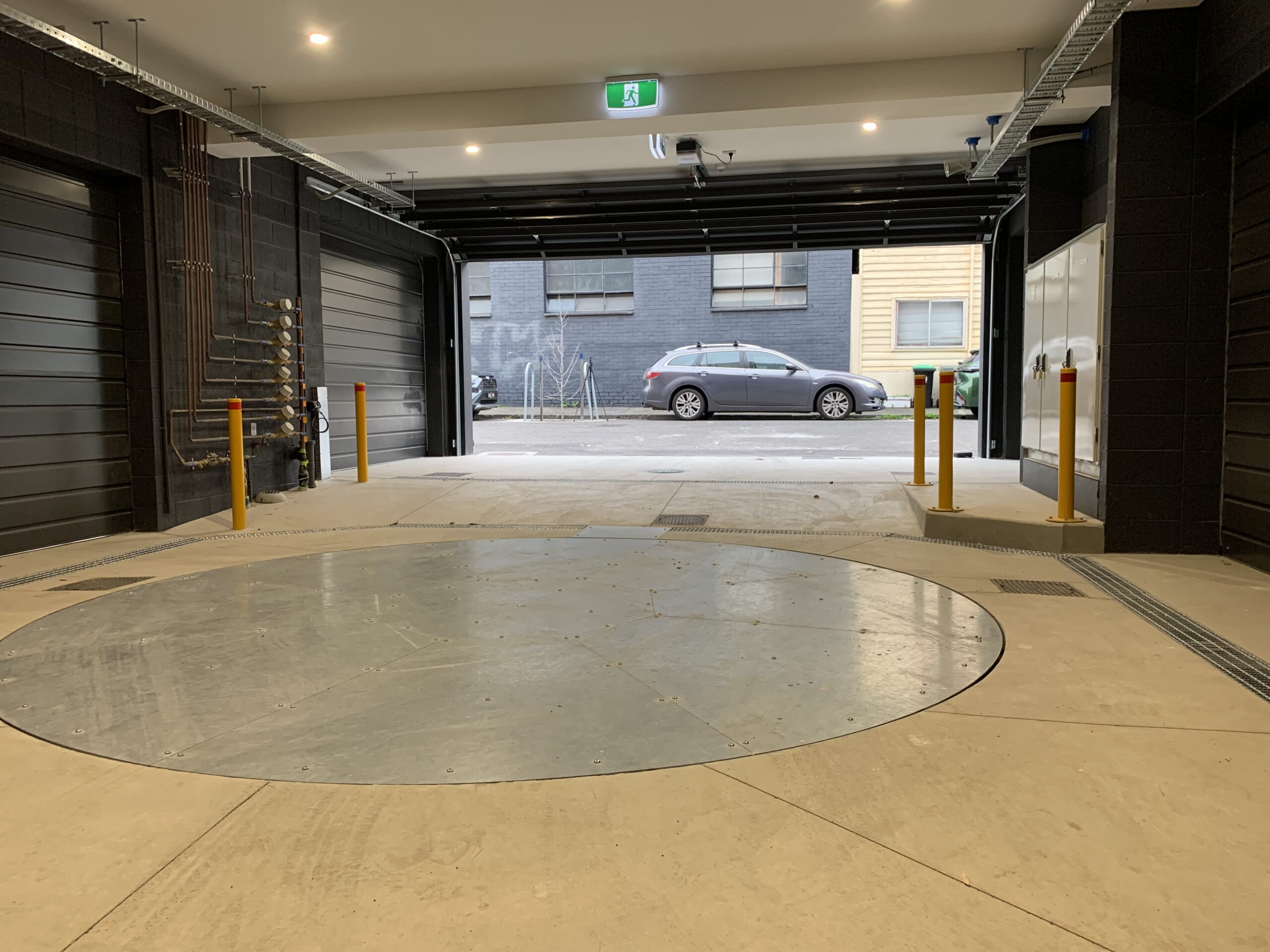 Finished garage turntable with open roller door and vehicle access